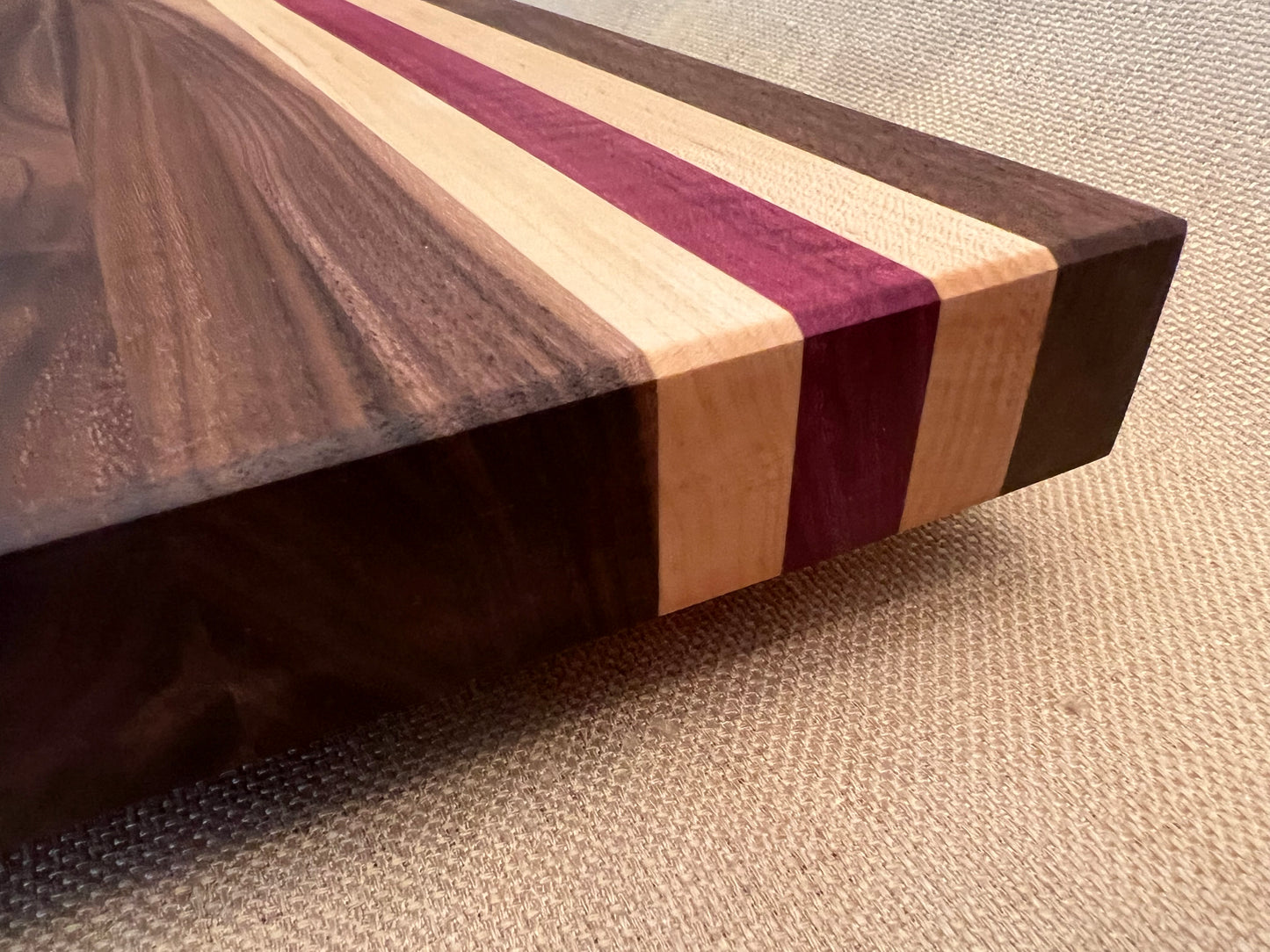 Personalized cutting board with beach theme is made out of three different woods, walnut with two maple stripes and a purple heart stripe.Aloha cutting board for your ohana. Hawaii beach design with Diamond Head and hibiscus flowers on a personalized cutting board. Ohana gift for her. Hawaii gift for her. Mothers Day gift for the Mom that loves Hawaii.