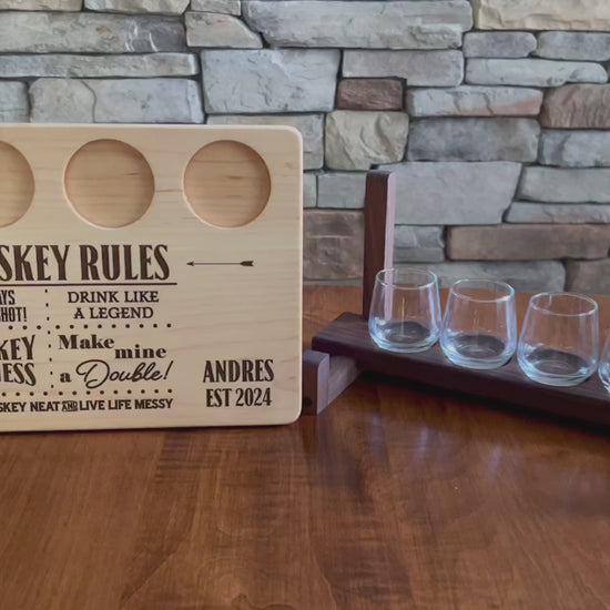 Personalized maple whiskey board shown with whiskey shot glasses and a shot glass holder. Whiskey rules theme drink like a legend. Perfect gift for whiskey drinker. ￼